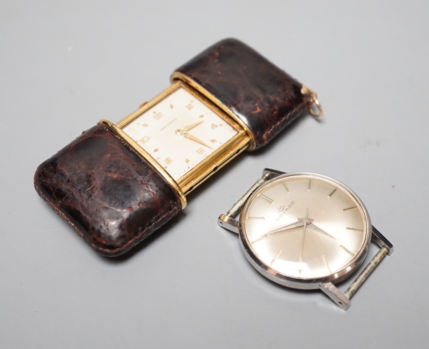 A Movado leather mounted gilt metal travelling timepiece, 49mm and a stainless steel Movado manual wind wrist watch(lacking winding crown).
